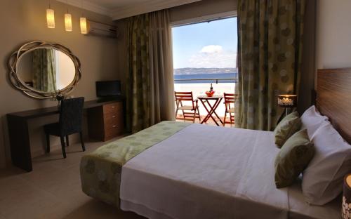 a bedroom with a bed and a view of the ocean at Sunrise Resort Hotel in Mithymna