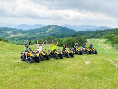 a group of people on atvs on a hill at Mineyama Kogen Hotel Relaxia in Kamikawa