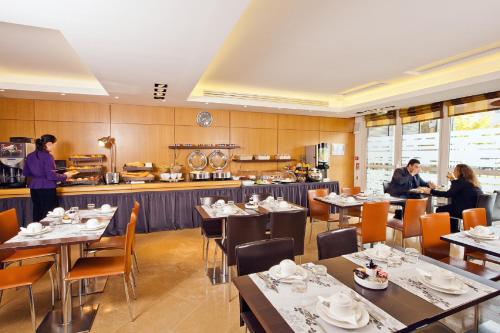 un restaurante con mesas y gente de pie en la cocina en Residhome Paris-Massy, en Massy