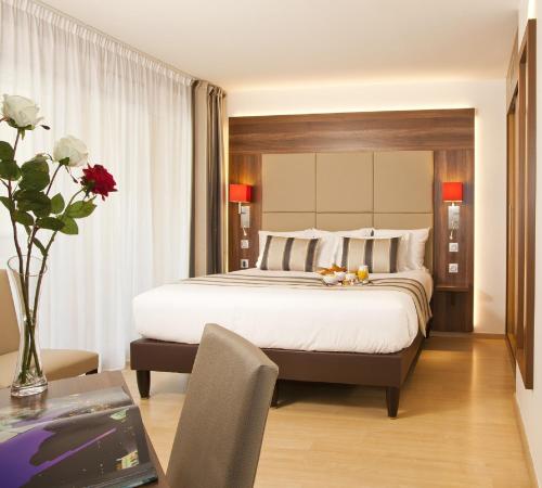 a bedroom with a large bed and a table with a laptop at Residhome Paris-Massy in Massy