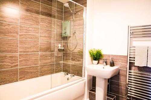 bagno con lavandino, doccia e vasca di A luxury 2 bedroom apartment with 2 free parking a Chatham