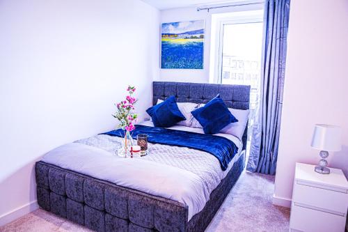 a bedroom with a bed with blue pillows and a window at A luxury 2 bedroom apartment with 2 free parking in Chatham