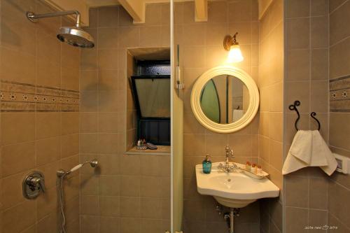 a bathroom with a sink and a shower and a mirror at Beit Ha'Omanim in Safed
