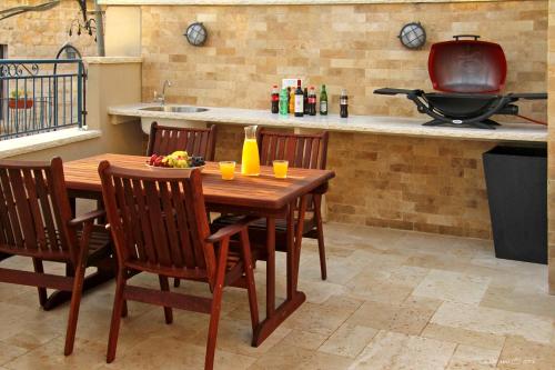 a kitchen with a wooden table with chairs and a stove at Beit Ha'Omanim in Safed