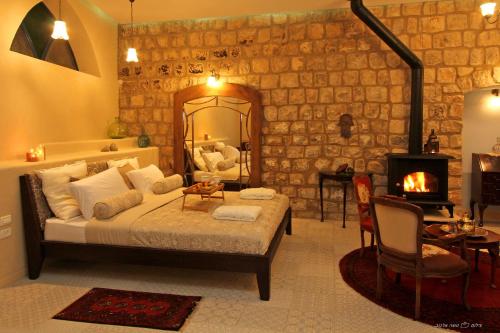 a bedroom with a bed with a mirror and a fireplace at Beit Ha'Omanim in Safed