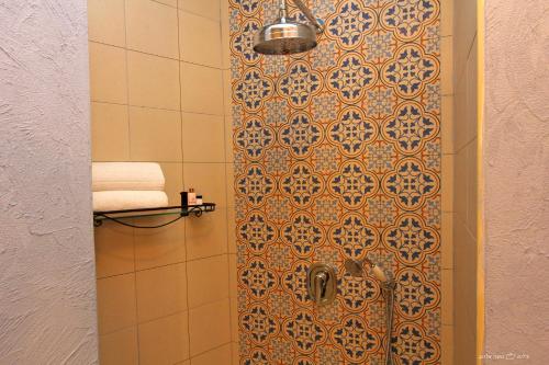 a bathroom with a shower with a tile wall at Beit Ha'Omanim in Safed