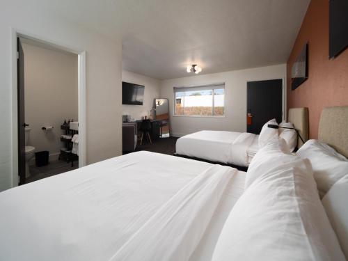 une chambre d'hôtel avec deux lits et un bureau dans l'établissement Motolodge, à Pendleton