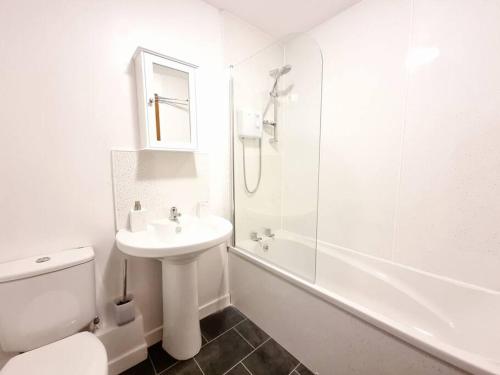 uma casa de banho branca com um WC e um lavatório em Two Bed Holiday Home with Free Parking in Inverness em Inverness
