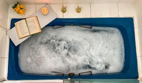 a bath tub filled with snow and a book at Suíte com Banheira, próximo à Praia Litorânea Limão Siciliano Limoneto House Eventos, Hostel e Pousada in São Luís