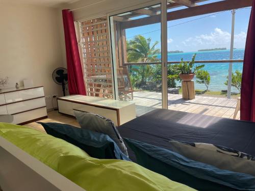 a bedroom with a bed and a view of the ocean at Studio Moana in Bora Bora