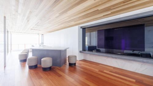 a living room with a large television and a table and stools at Soukyu 蒼穹 #TB1 in Yonago