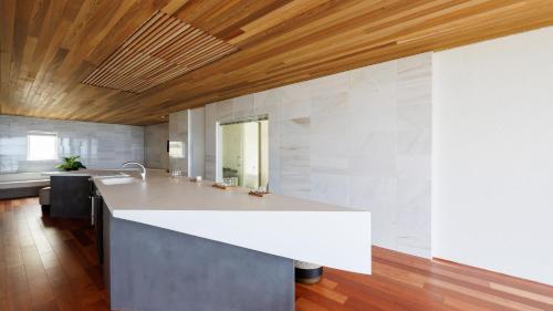 a kitchen with a white counter and a wooden ceiling at Soukyu 蒼穹 #TB1 in Yonago