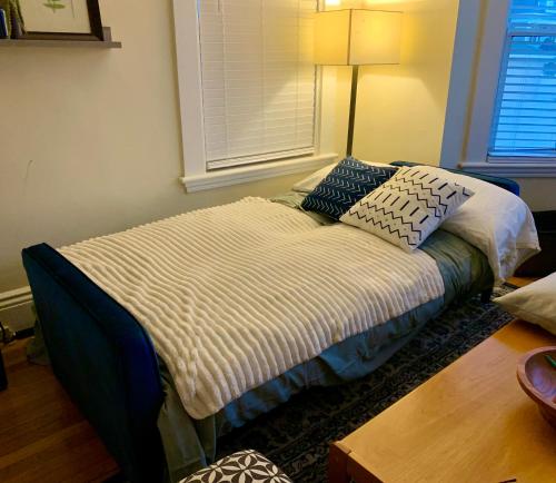 a bed with pillows on it in a room at Bright 2 Br, Pets Welcome, Steps to Lake, Restaurants and Train in Wakefield