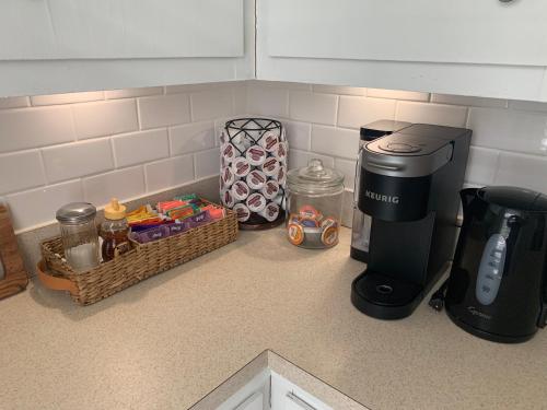 a coffee maker on a kitchen counter next to a basket at Bright 2 Br, Pets Welcome, Steps to Lake, Restaurants and Train in Wakefield