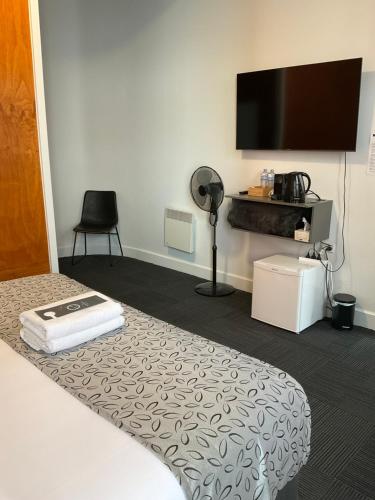 a hotel room with a bed and a flat screen tv at Argyle Accommodation in Hobart