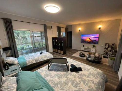 a bedroom with two beds and a flat screen tv at Dream Holiday Condo with Caravan Parking Kallangur in Kallangur
