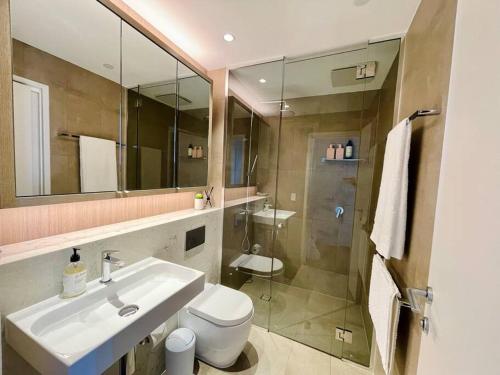 a bathroom with a sink and a toilet and a mirror at Luxury 2Beds Condo with stunning city View (Parking, Gym) in Sydney
