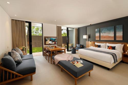 a hotel room with a bed and a living room at Citadines Berawa Beach Bali in Canggu