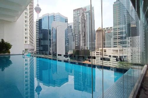 una piscina en una ciudad con edificios altos en A05 Bukit Ceylon KL Tower View Balcony Apartment, en Kuala Lumpur