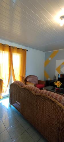 a living room with a couch and two windows at Le petit cactus 1 in Bras-Panon