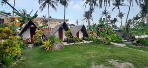 a house with a yard and palm trees at Dream Catcher Nipas Siargao in General Luna