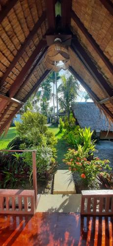 a view of a garden with two benches under a roof at Dream Catcher Nipas Siargao in General Luna