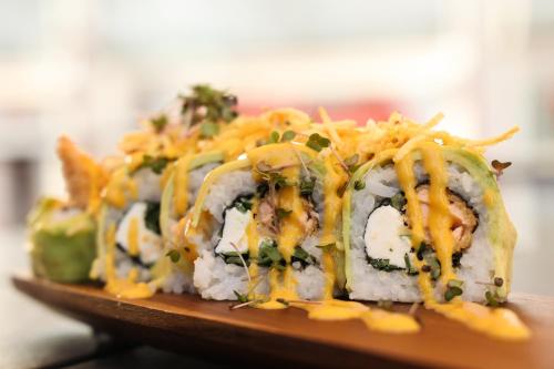 a group of sushi on a wooden plate at Hotel Sommelier Agustinas in Santiago