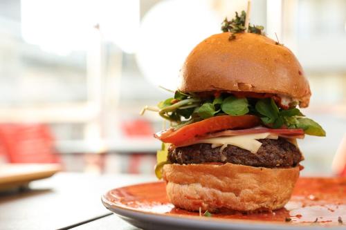 a hamburger on a plate on a table at Hotel Sommelier Agustinas in Santiago