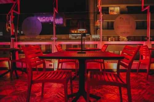 a dining room with red chairs and a table at Hotel Sommelier Agustinas in Santiago