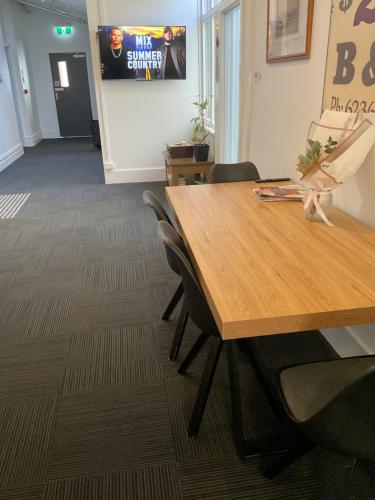a conference room with a wooden table and chairs at Argyle Accommodation in Hobart