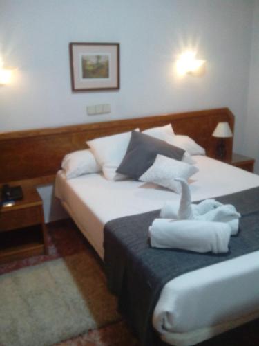a bedroom with a bed with two towels on it at Complejo Hotelero Saga in Manzanares