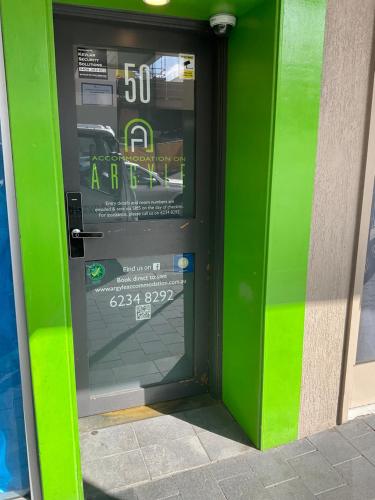 a green door with a sign on it at Argyle Accommodation in Hobart