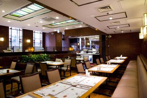 a restaurant with tables and chairs and a bar at Garden Hotel Kanazawa in Kanazawa