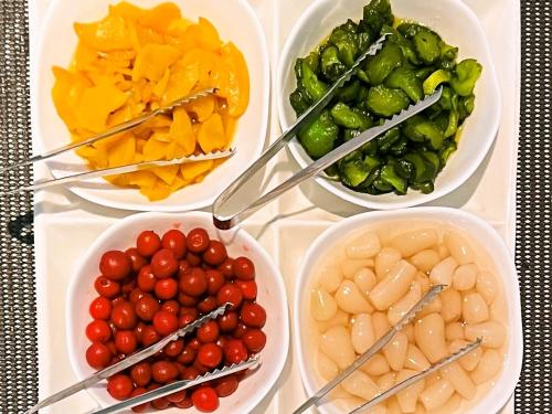 a table with four bowls of different types of vegetables at Suizenji Comfort Hotel in Kumamoto
