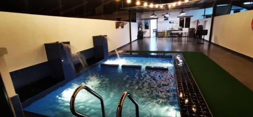 eine große Whirlpool-Badewanne in einem großen Zimmer mit Beleuchtung in der Unterkunft Bahagia 137 Homestay with private pool in Port Dickson