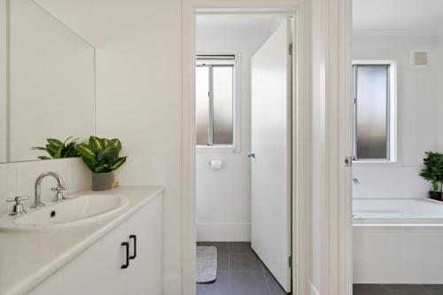 a white bathroom with a sink and a tub at Big Blue Tailem Bend in Tailem Bend