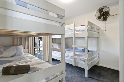 a bedroom with two bunk beds and a staircase at Big Blue Tailem Bend in Tailem Bend