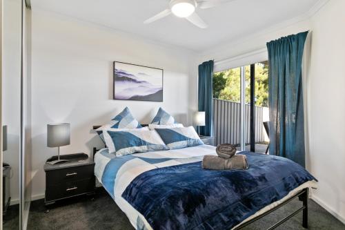a bedroom with a bed with blue and white pillows at Big Blue Tailem Bend in Tailem Bend