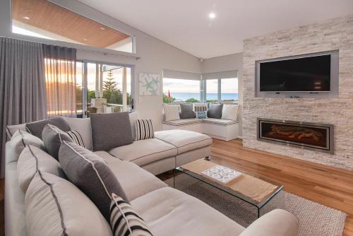 a living room with a couch and a fireplace at Busselton Beach House in Busselton