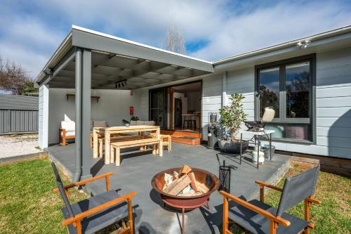 a patio with chairs and a table and a fire pit at 'Mudgee Burrow' A Stylish Central Family Stay in Mudgee