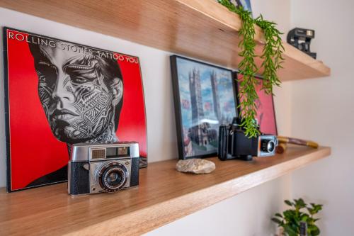 a shelf with a camera and a picture on it at 'Mudgee Burrow' A Stylish Central Family Stay in Mudgee