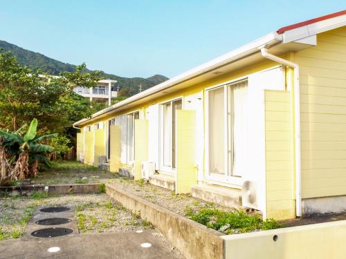 a row of yellow houses sitting next to each other at AsobiBASE Yamabare-House in Ishigaki Island