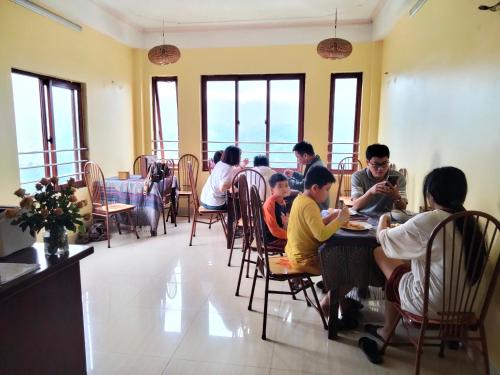 un groupe de personnes assises à une table dans un restaurant dans l'établissement Black Hmong View hotel, à Sa Pa