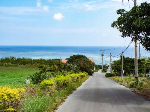 an empty road with the ocean in the background at AsobiBASE Yamabare-House in Ishigaki Island