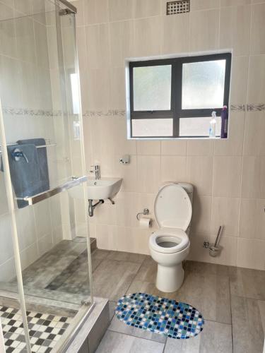 uma casa de banho com um chuveiro, um WC e um lavatório. em Heavenly Towers em Mbazwana