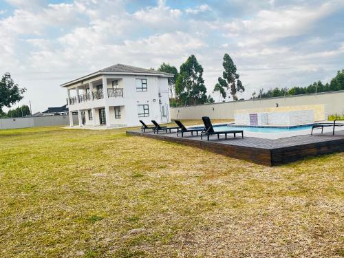 Heavenly Towers في Mbazwana: منزل فيه مسبح وكراسي في ساحة