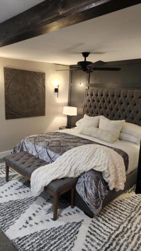 a large bedroom with a large bed with a bench at Town Square Retreat in Blairsville