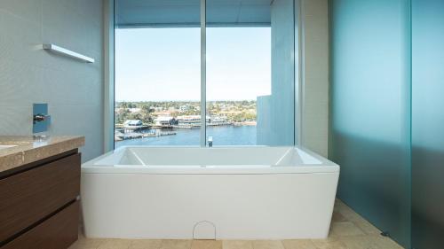 a bath tub in a bathroom with a large window at Bayview 705 in Mandurah