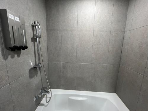 een badkamer met een douche en een bad bij Incheon Rivieraverium Hotel in Incheon