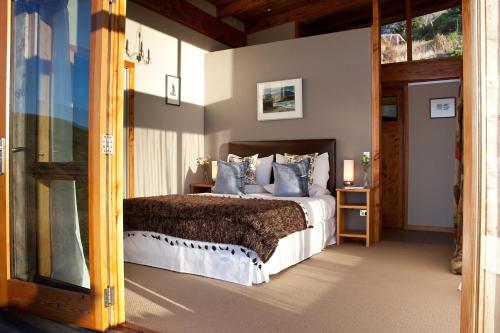 a bedroom with a large bed and a doorway at Kaimata lodge in Dunedin
